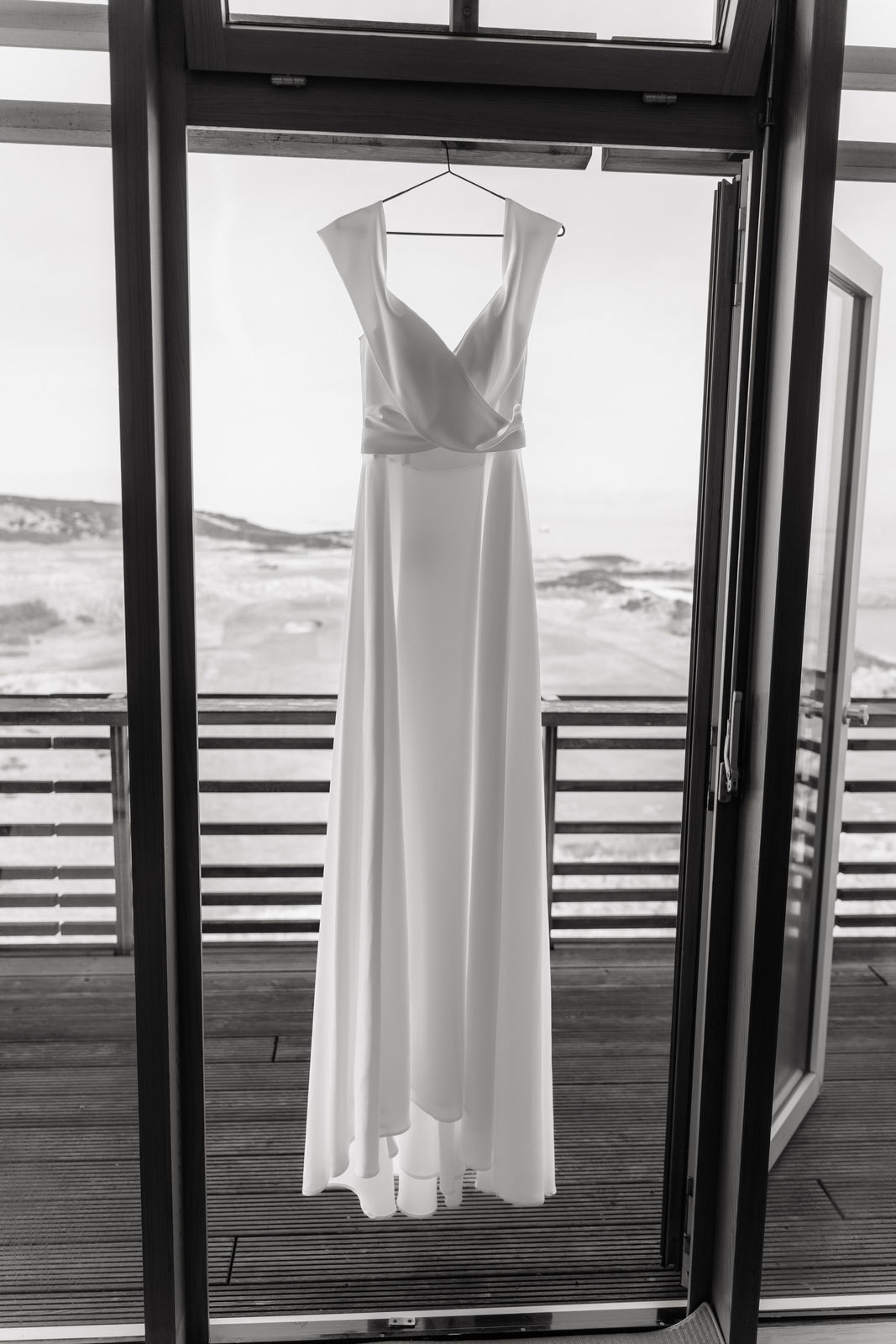 Brautkleid auf einem Bügel vor der Fensterfront mit Blick über die Dünen von Sylt