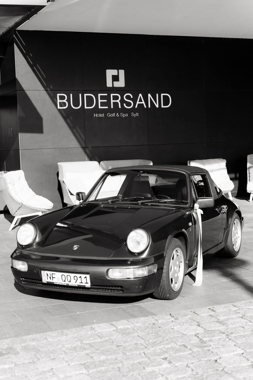 Schwarzer Porsche als Hochzeitsauto vor dem Eingang des Budersand Hotels auf Sylt