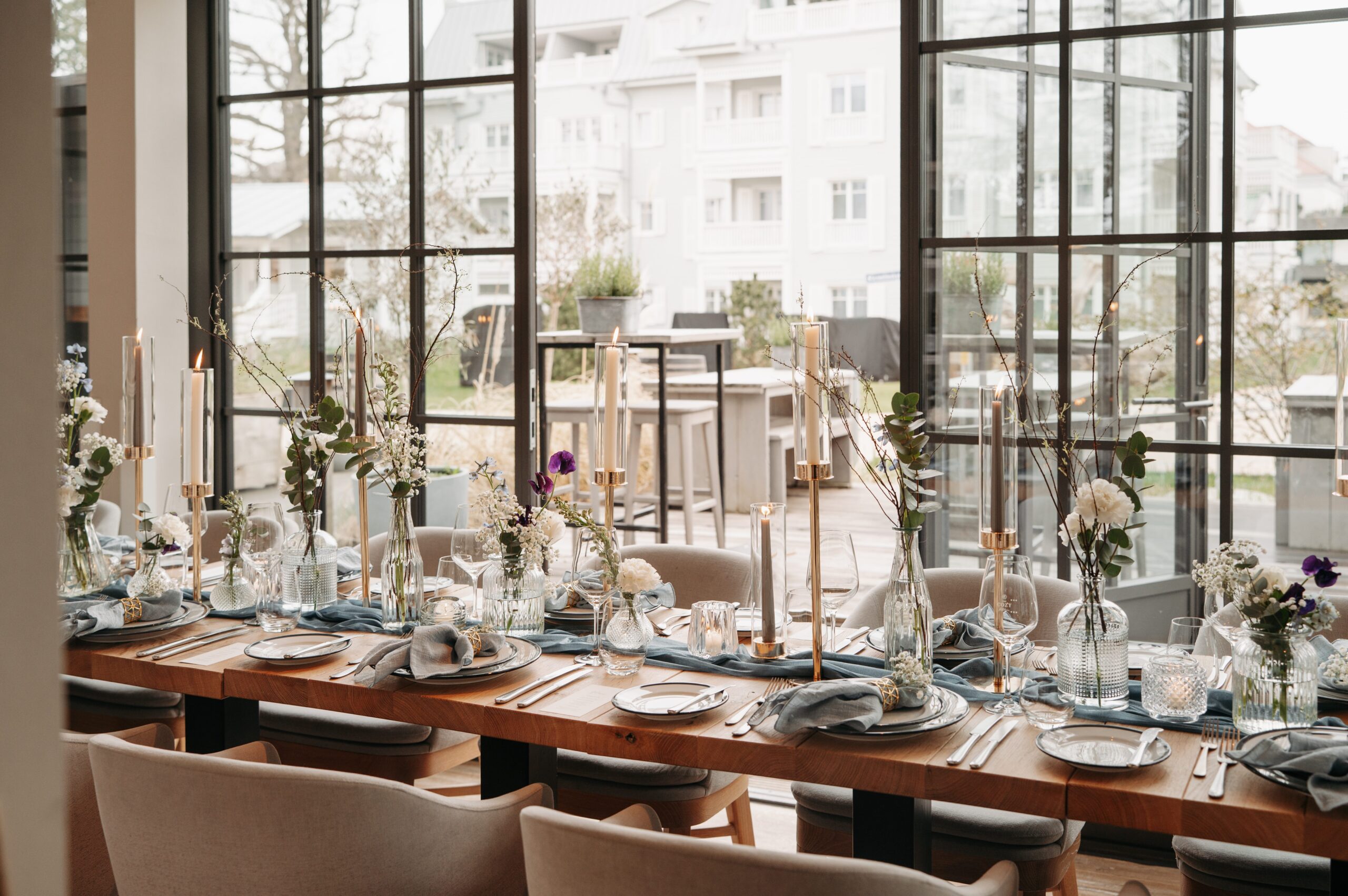 Lange Hochzeitstafel mit blauem Tischläufer und goldenen Kerzenhaltern im The Cozy Hotel