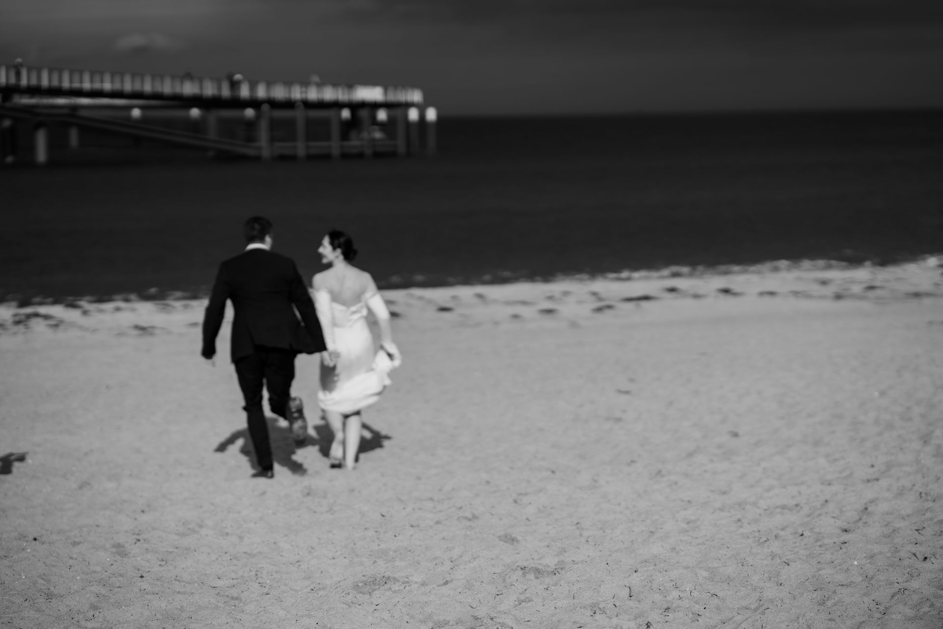 Brautpaar am Strand der Ostsee, im Hintergrund die Seebrücke