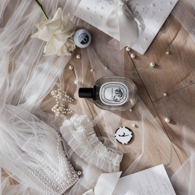 Brautaccessoires auf dem Schleier: Parfum, Perlenohrringe und Papeterie